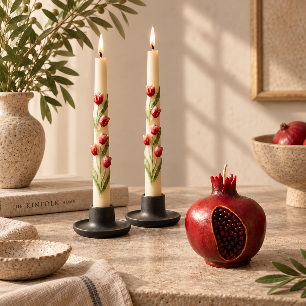 Two ivory floral taper candles with red tulip details beside a handmade red pomegranate candle in an elegant neutral home decor setting. Votive Candle CO