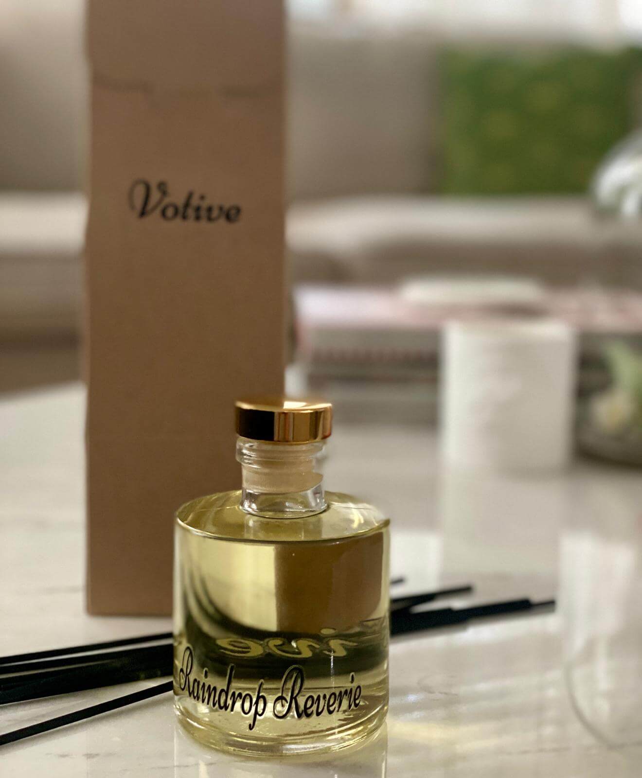 Aromatic Eclipse reed diffuser next to books and a ceramic mug for cozy home vibes