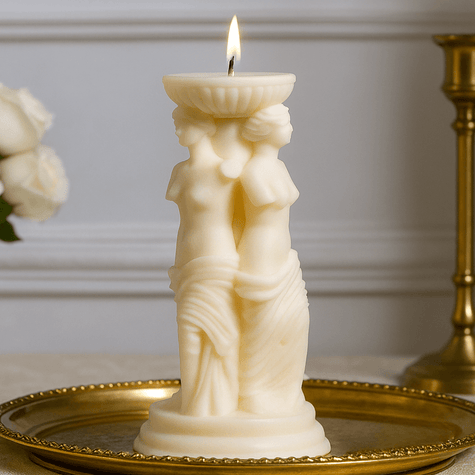 Decorative candle with sculpture design on a gold tray