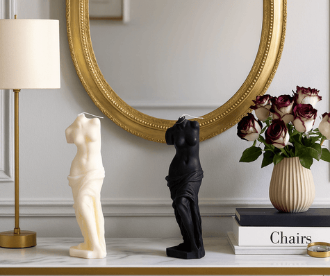 Decorative scented Venus candles on a shelf including books, a vase with flowers, and a lamp.