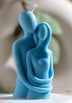 Blue sculptural soy wax candle depicting an abstract embrace between two figures, symbolizing love and connection. A minimalist, eco-friendly candle perfect for artistic home décor or meaningful gifting.