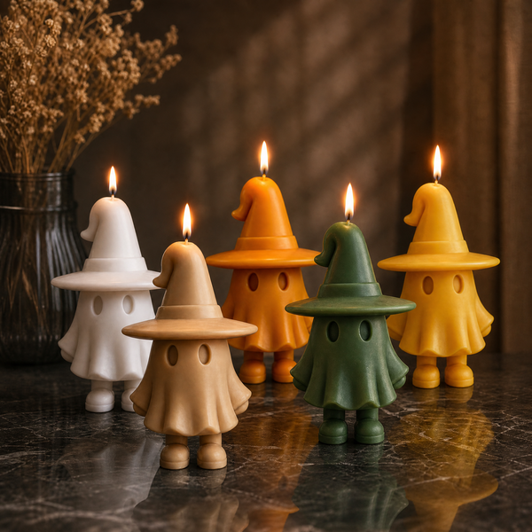 Five small wizard-shaped candles in white, beige, orange, green, and yellow are arranged on a dark reflective surface with a vase of dried flowers in the background. candles by Votive Candle Co