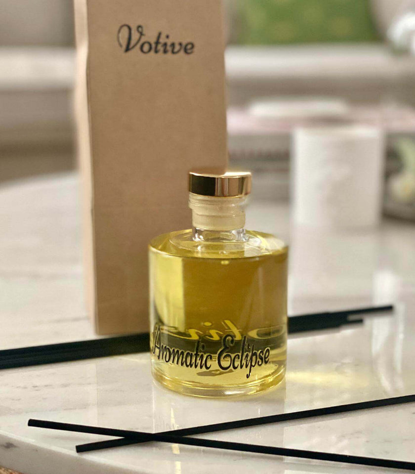 Collection of VOTIVE reed diffusers arranged in a sunlit living room with minimalist design