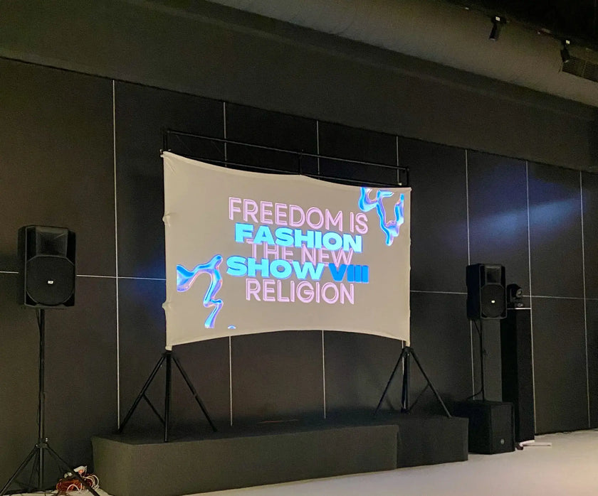 Backdrop with motivational quote on a stage setup with speakers.