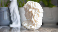 Luxury sculptural candle shaped like Medusa, made from eco-friendly soy wax and infused with a refined fragrance.