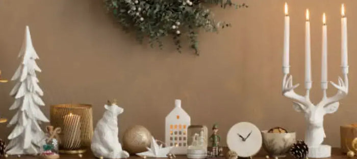 White winter decor with a lit candelabra, tiny trees and reindeer figurines