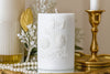 White candle with 'Joy' embossed, surrounded by gold and pearl decor