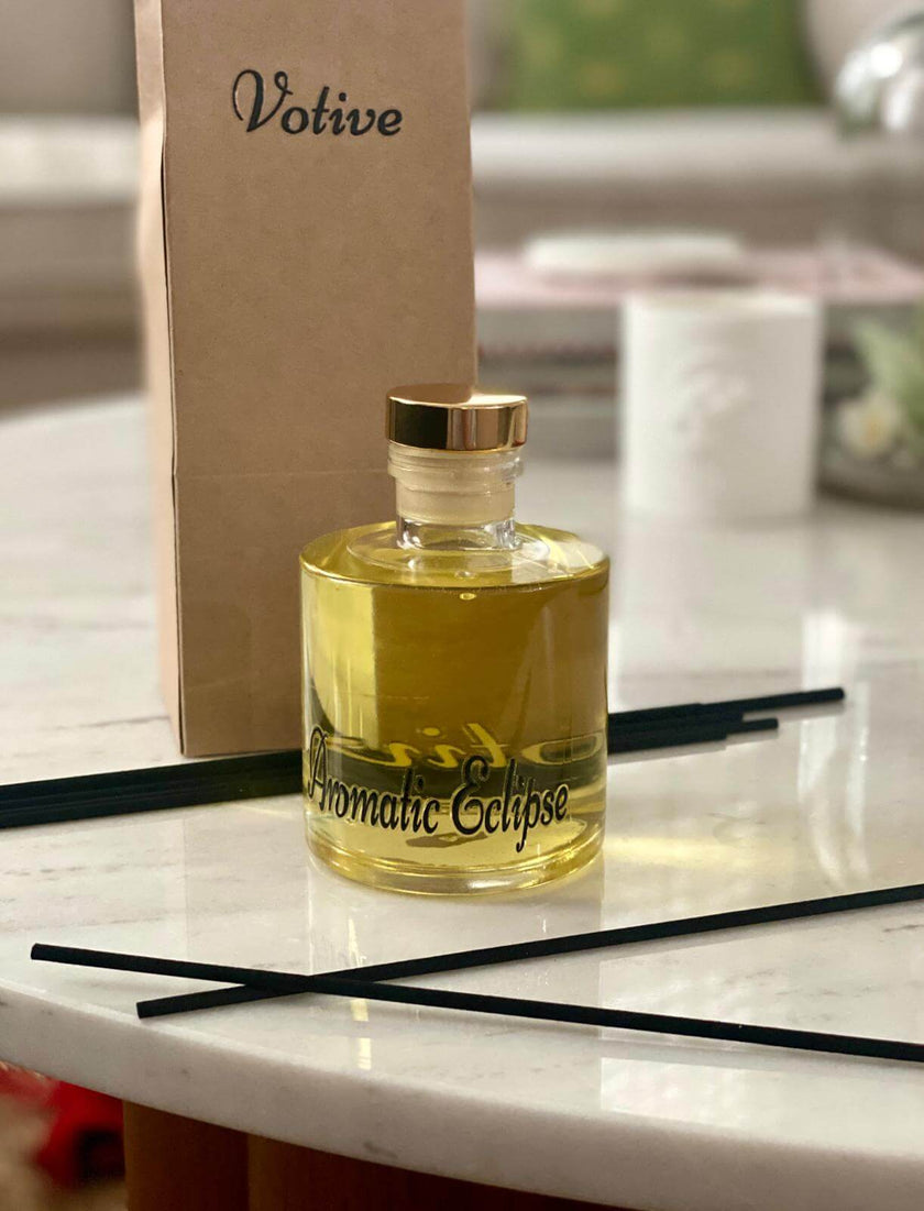 Aromatic Eclipse reed diffuser with white flowers and candles for a relaxing spa atmosphere

