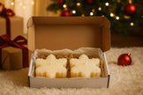 Box of Christmas-themed candles with a festive background