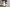 Cat-shaped white scented candle on a gold tray with a blurred background