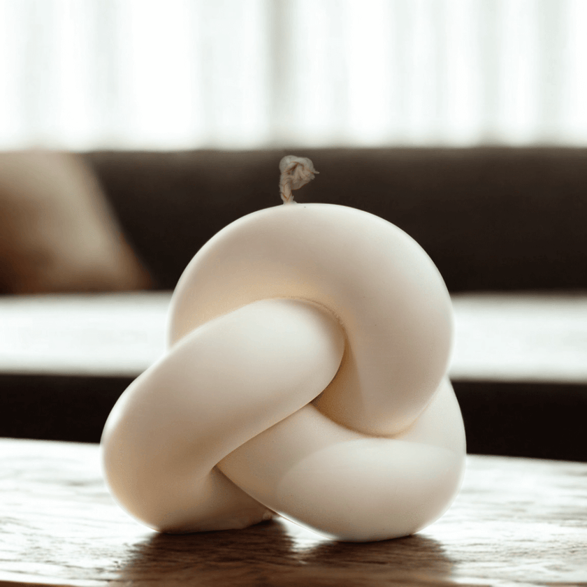 Decorative knot candle on a wooden surface with a blurred background