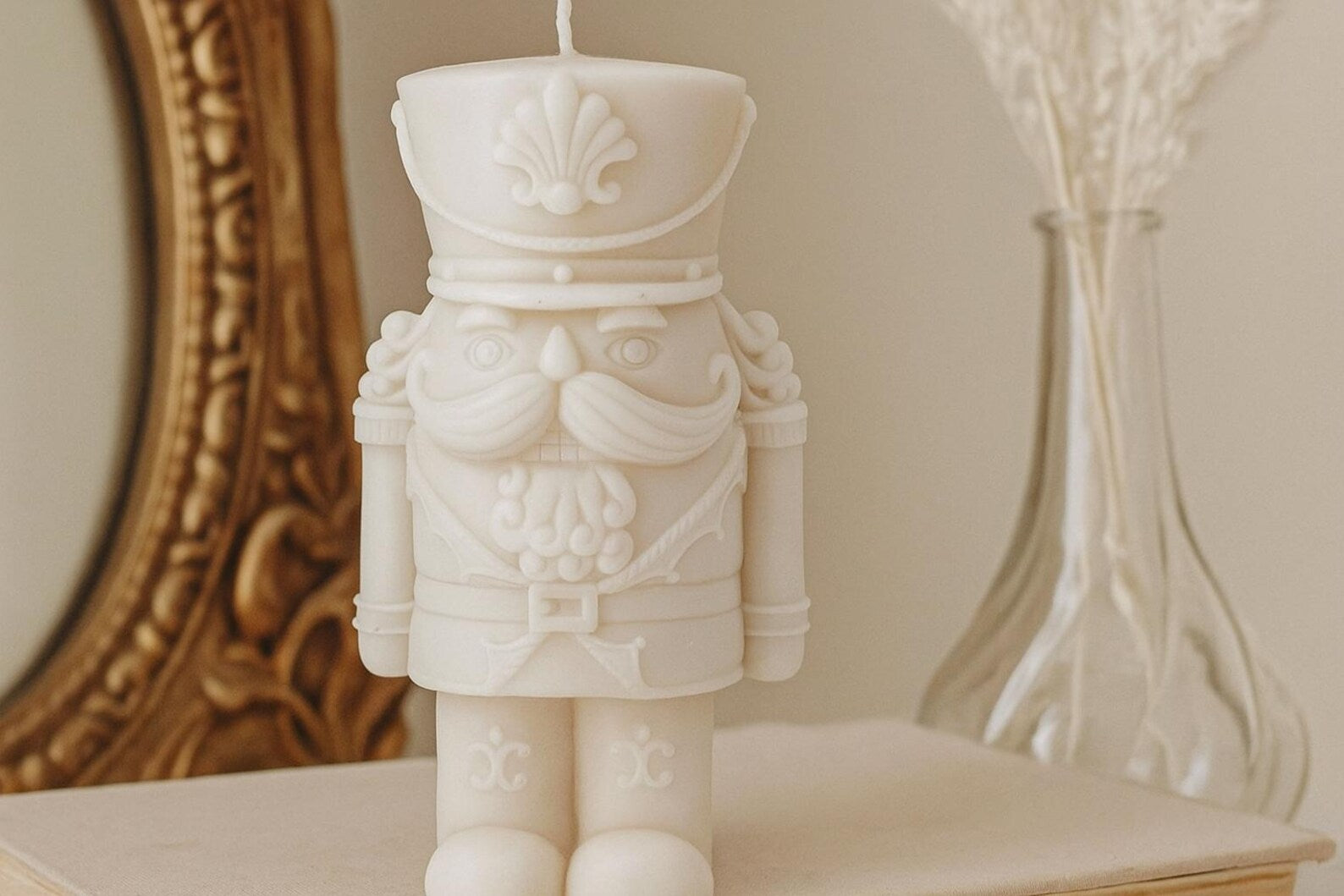 White nutcracker candle on a surface with decorative background