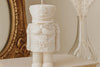 White nutcracker candle on a surface with decorative background