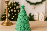 Green Christmas tree-shaped candle on a wooden surface with festive decorations in the background.