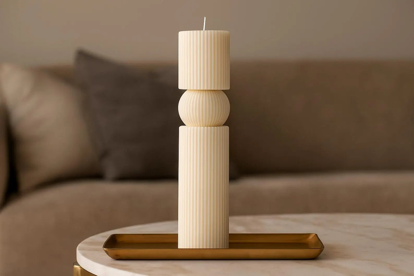 Decorative candle on a wooden stand with a blurred sofa in the background