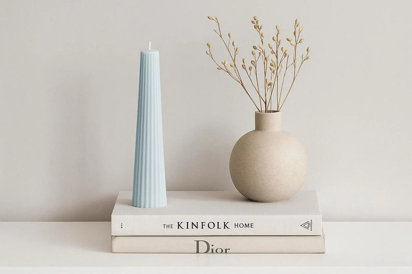 Striped Candle and vase on top of books with a neutral background