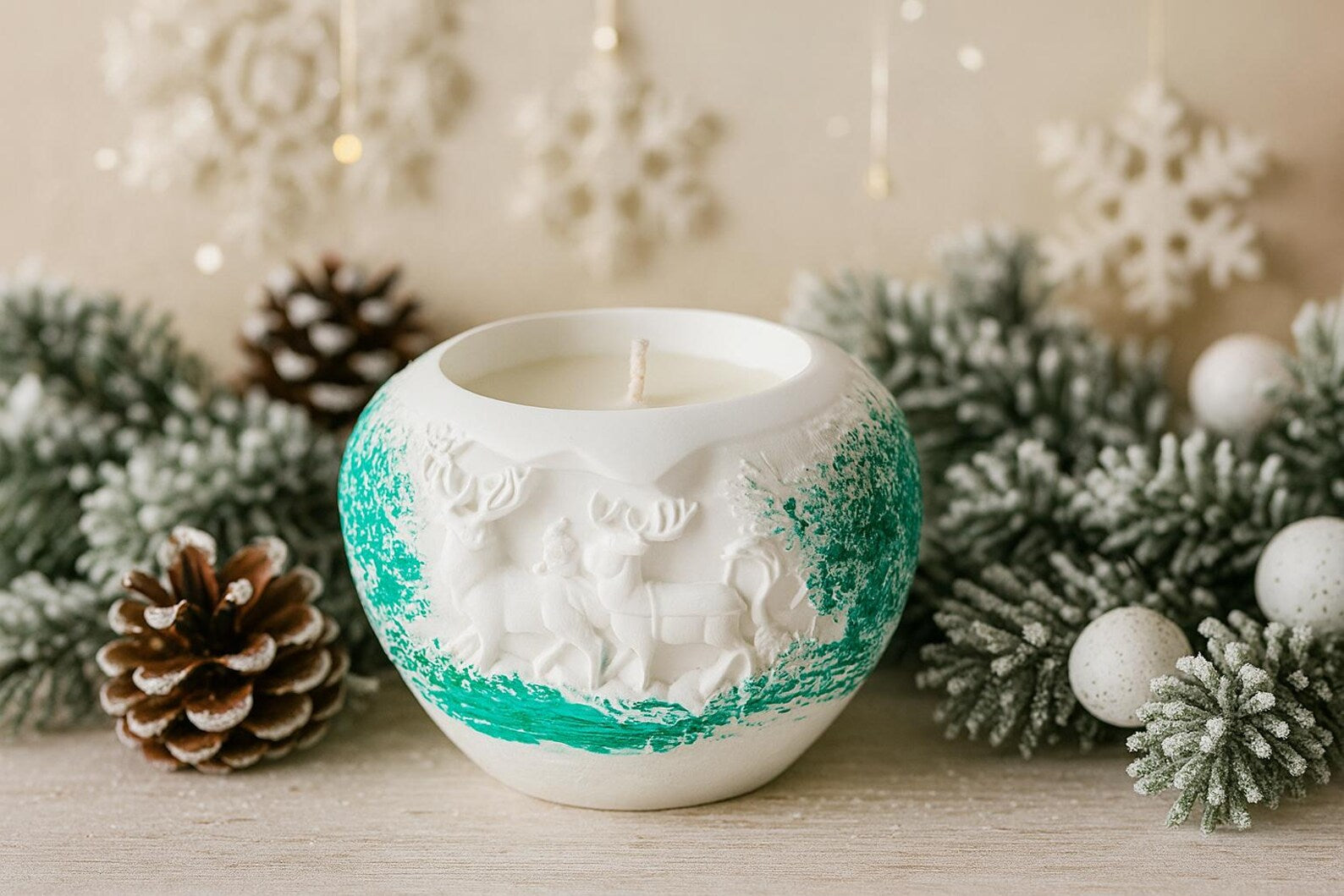 Decorative candle in a white holder with green accents, surrounded by Christmas decorations.