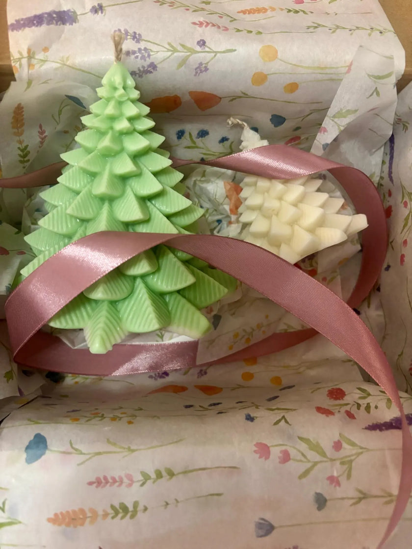 Green Christmas tree-shaped soap with a pink ribbon on floral-patterned paper