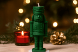 Green nutcracker candle with a blurred festive background