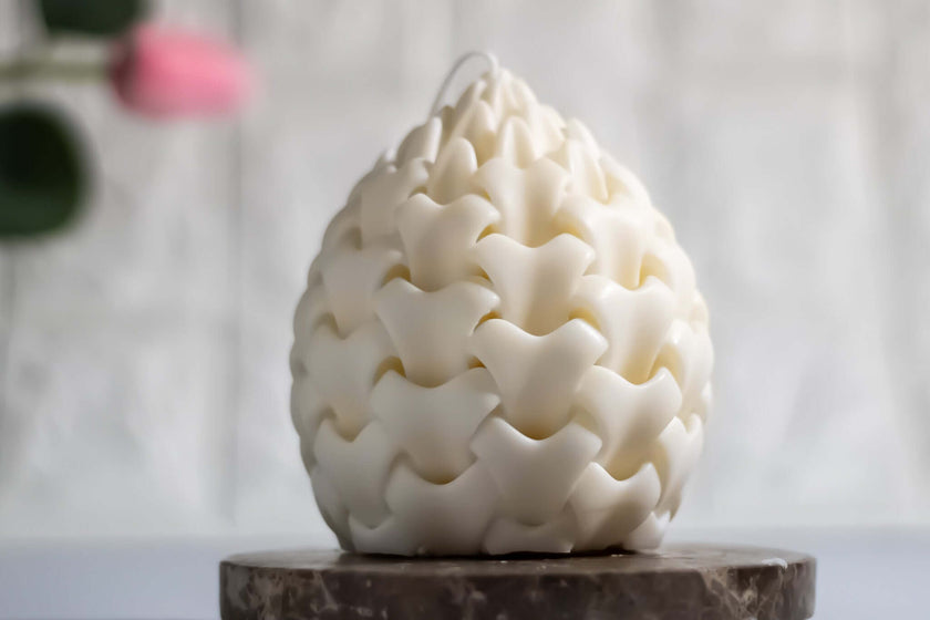 Non-toxic handcrafted white candle in unique layered design, placed on a marble base, ideal for eco-friendly decor.