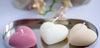 in pink, white, and beige on a metallic tray with a blurred floral background.