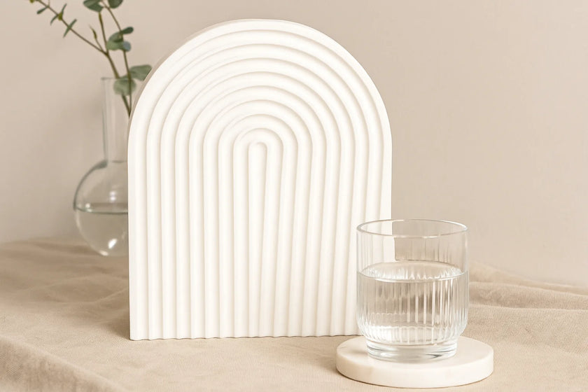 Decorative arch with a glass of water on a neutral background