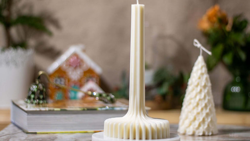 Handcrafted festive scented candle with elegant design on a table, creating a warm holiday atmosphere.