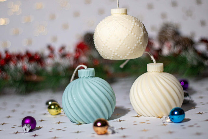 Three artisan globe candles in pastel colors, perfect for festive decor and holiday gifts.