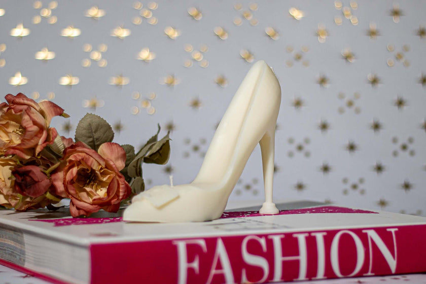 High Heel Decorative Candle on a fashion book, surrounded by roses, showcasing its elegant design and eco-friendly appeal.