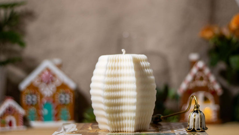 Natural scented candle with a textured design, set against a festive backdrop of gingerbread houses.