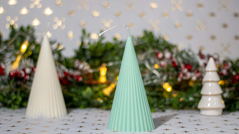 Handcrafted Christmas tree decorative candles in green and white, set against a festive backdrop for holiday gifting.