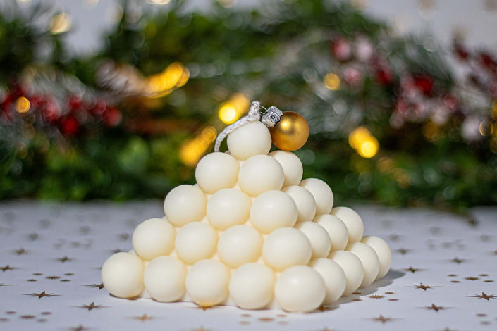 Elegant pyramid-shaped scented candle made of natural soy wax, perfect for festive decor and celebrations.