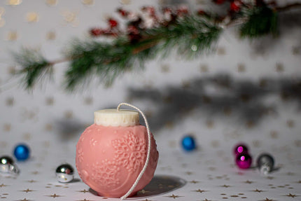 Handcrafted globe-shaped candle with delicate snowflake engravings, infused with a cozy holiday fragrance.