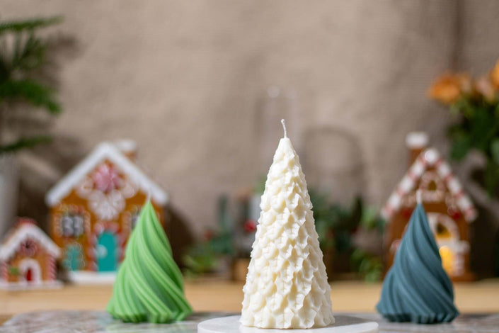 Close-up of the Christmas tree-shaped candle, featuring intricate textured details that mimic snow-covered branches.