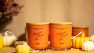 Close-up of the Harvest Moon Glow candle in a minimalist glass jar, releasing cozy fall aromas like spice and woodsy notes.