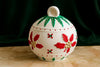 Decorative ceramic pot with floral patterns on a dark green background