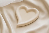 Heart-shaped object on a beige fabric background