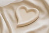 Heart-shaped object on a beige fabric background