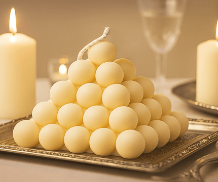 Candle pyramid on a decorative tray with candles and a glass in the background