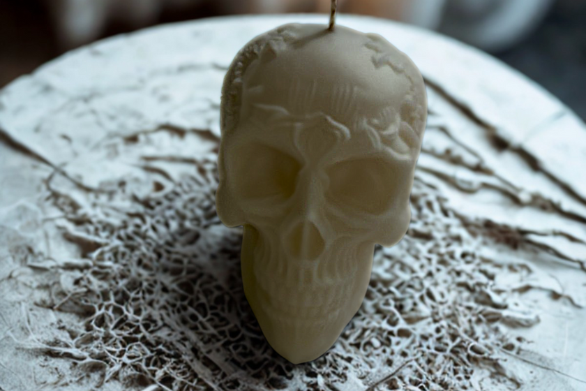 Skull-shaped candle on a textured surface
