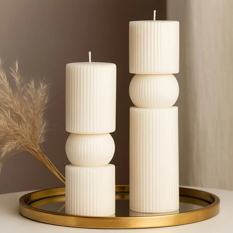 Decorative candle holder with candles on a round gold tray against a neutral background