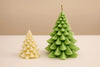 Two Christmas tree-shaped candles, one beige and one green, on a beige background.
