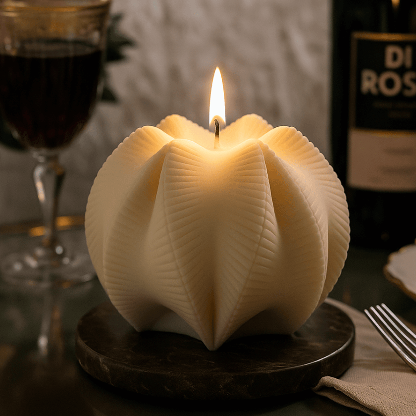 Candle in a unique holder on a table with wine and a bottle in the background