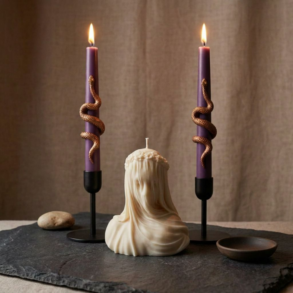 Sculptural snake taper candles styled on a dark marble table