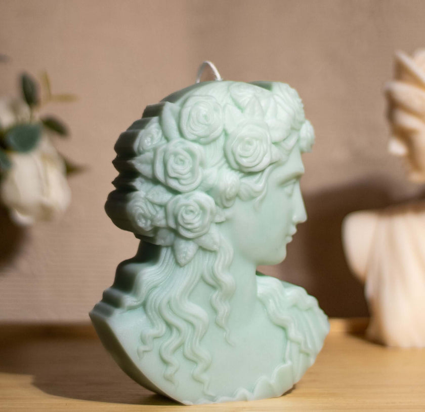 Sculptural Greek Goddess candle in green soy wax with floral detail, embodying elegance and femininity.