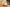 Decorative candle on a wooden base with candles and flowers in the background