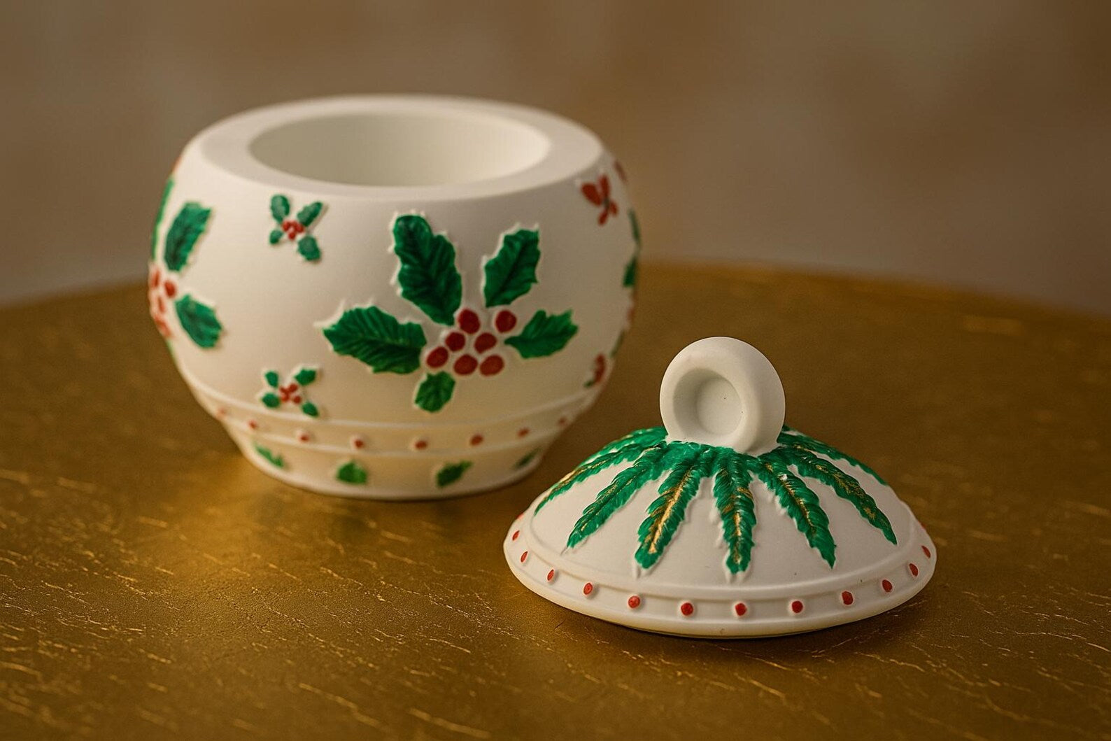 Decorative ceramic pot with holly design on a gold surface