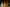 Three Halloween-themed candles in white, yellow, and orange on a reflective surface with a blurred background.