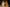 Two Halloween-themed candles, one white and one orange, with pumpkin shapes on a dark background.