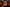 Halloween-themed decoration with a white pumpkin-shaped house, orange witch hat, black candles, and pumpkins on a dark background.